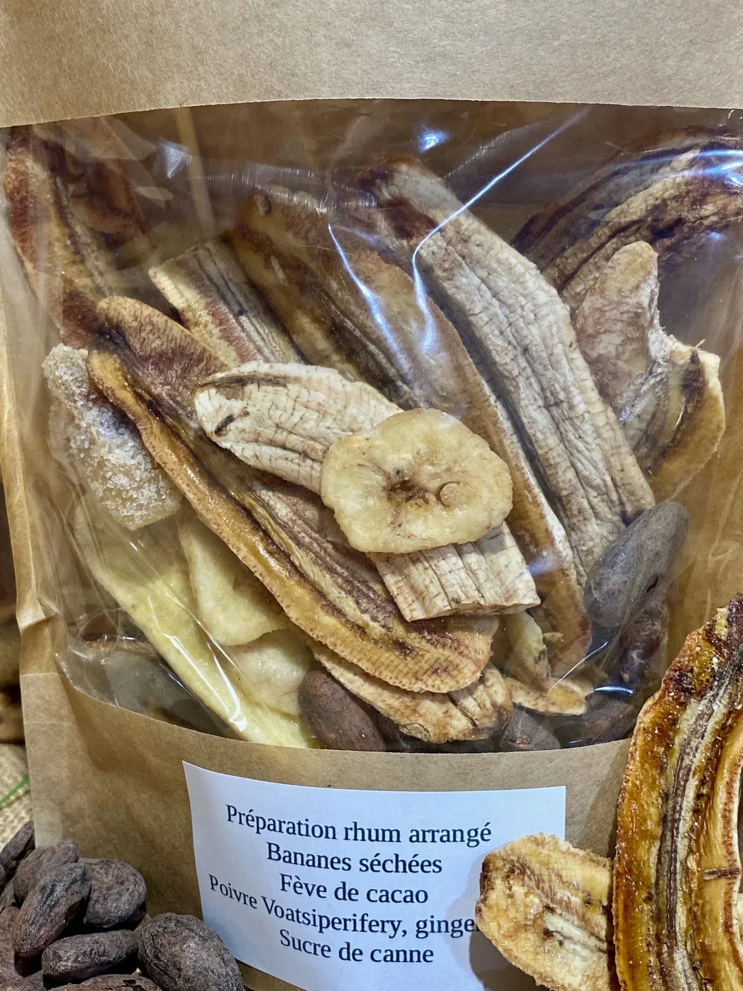 Sachet de préparation pour rhum arrangé cacao bananes ouvert – morceaux de cacao et bananes séchées prêts à être versés dans une bouteille pour infusion maison