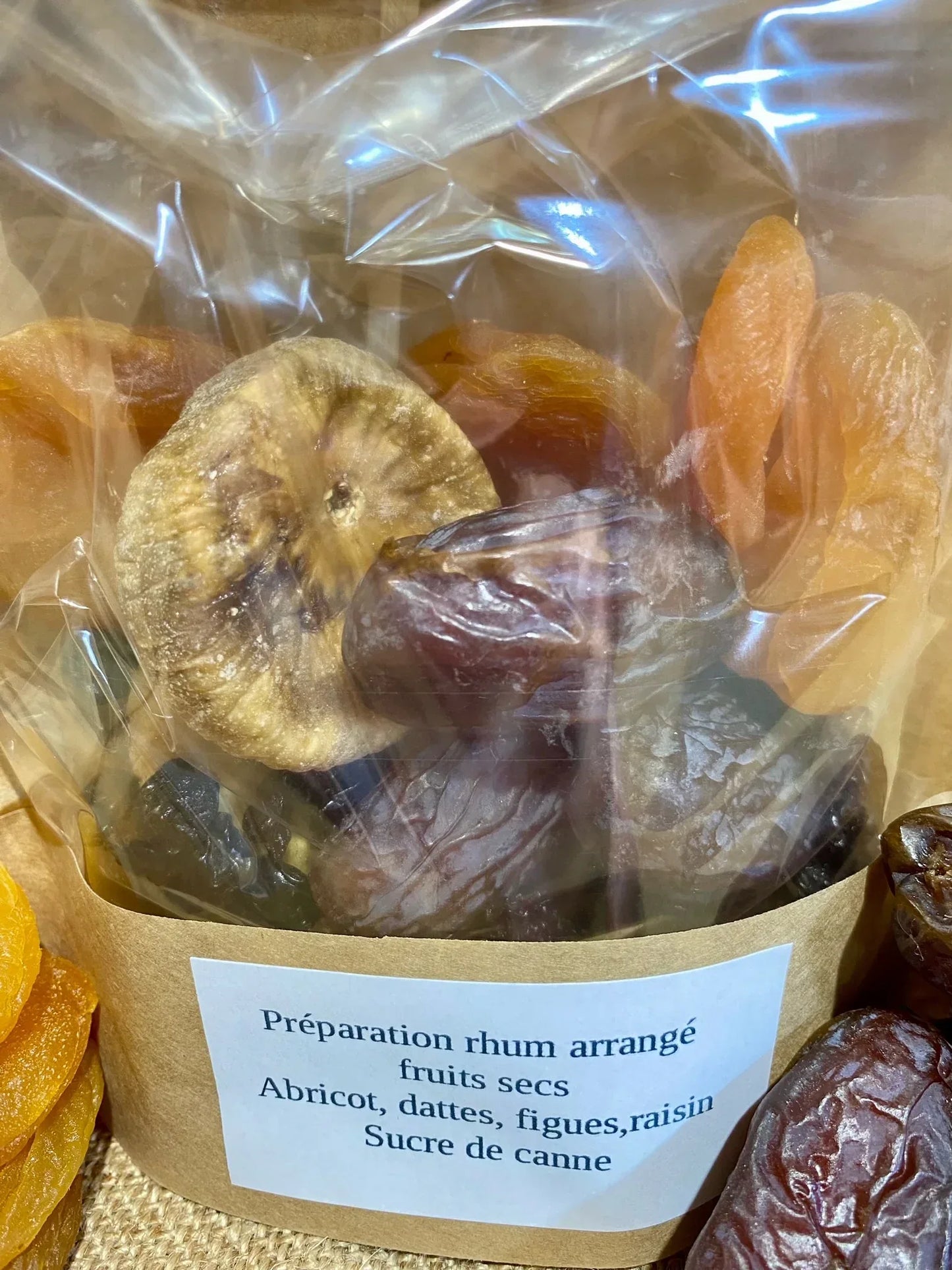 Sachet de préparation pour rhum arrangé fruit sec ouvert montrant les fruits séchés et le sucre de canne prêt à être utilisé dans la recette