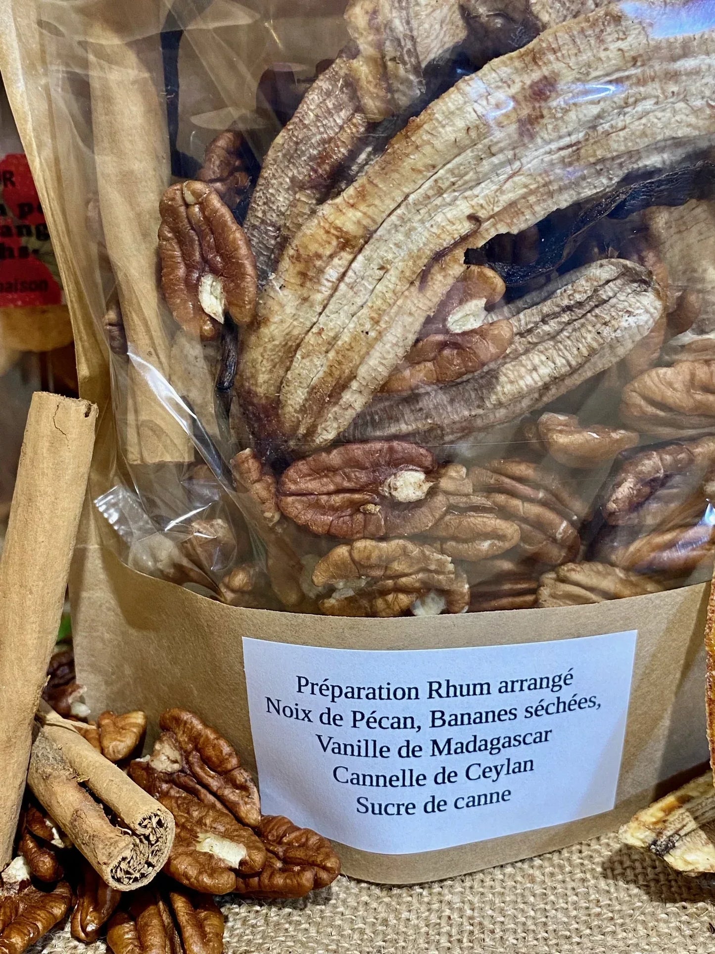 Table d’ingrédients pour rhum arrangé noix de pécan – assortiment de noix de pécan, bananes séchées, vanille, cannelle et sucre de canne prêt pour macération dans du rhum blanc agricole