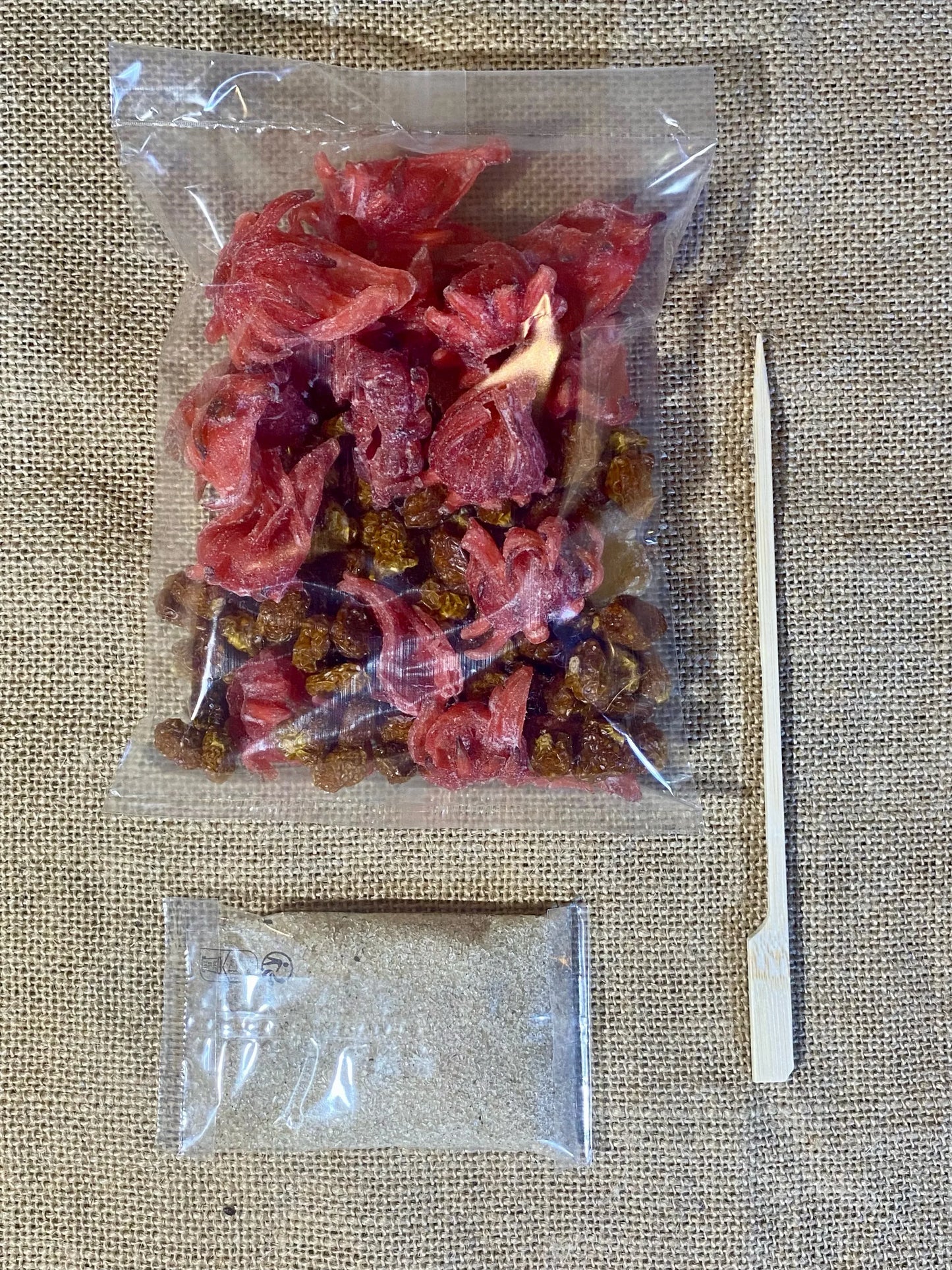 Sachet de préparation pour rhum arrangé Physalis Hibiscus ouvert – montre physalis séchés, hibiscus et gingembre prêts à être versés dans une bouteille pour macération