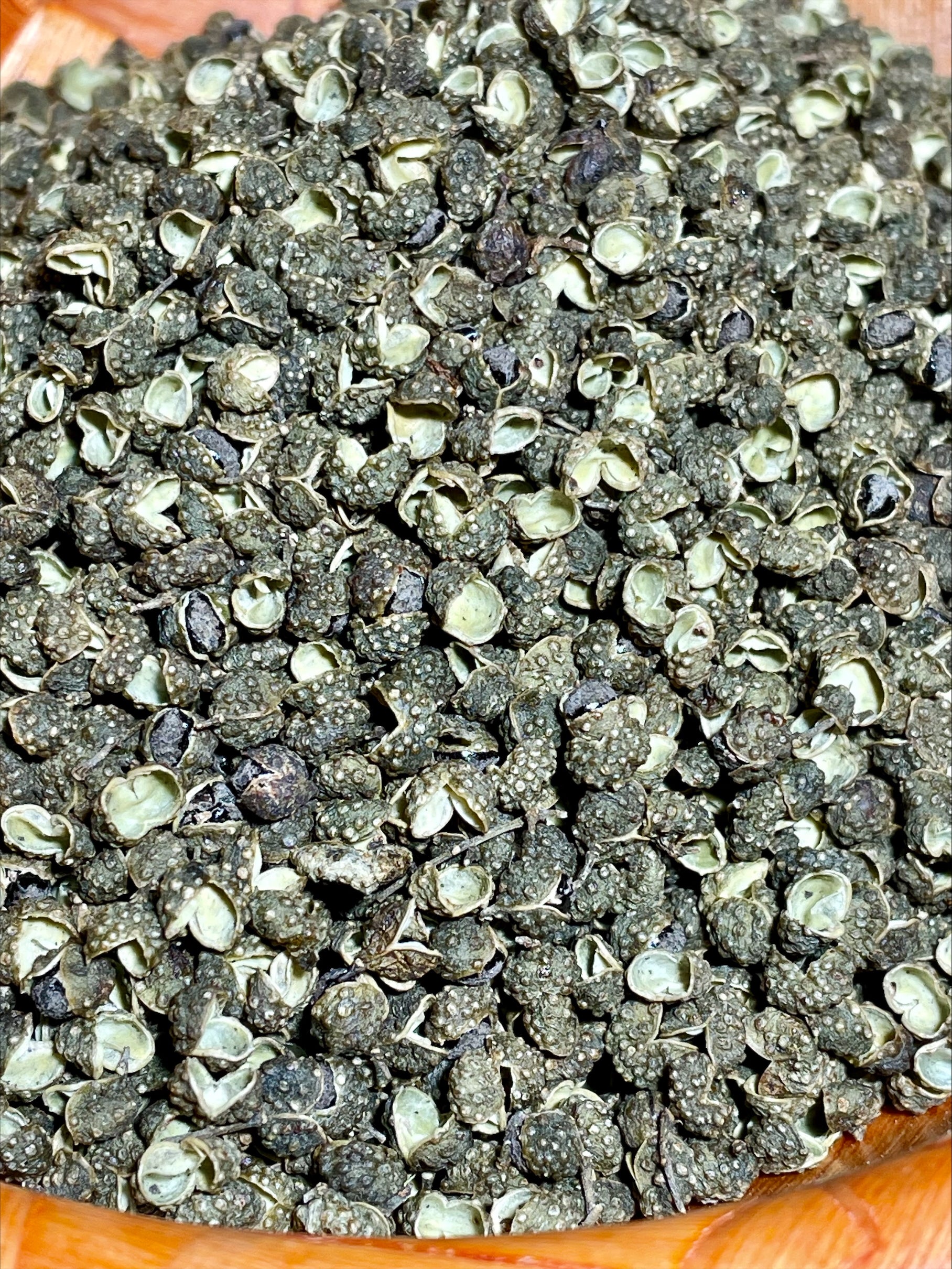 Détail des grains de poivre de Sichuan vert, épice rare récoltée jeune
