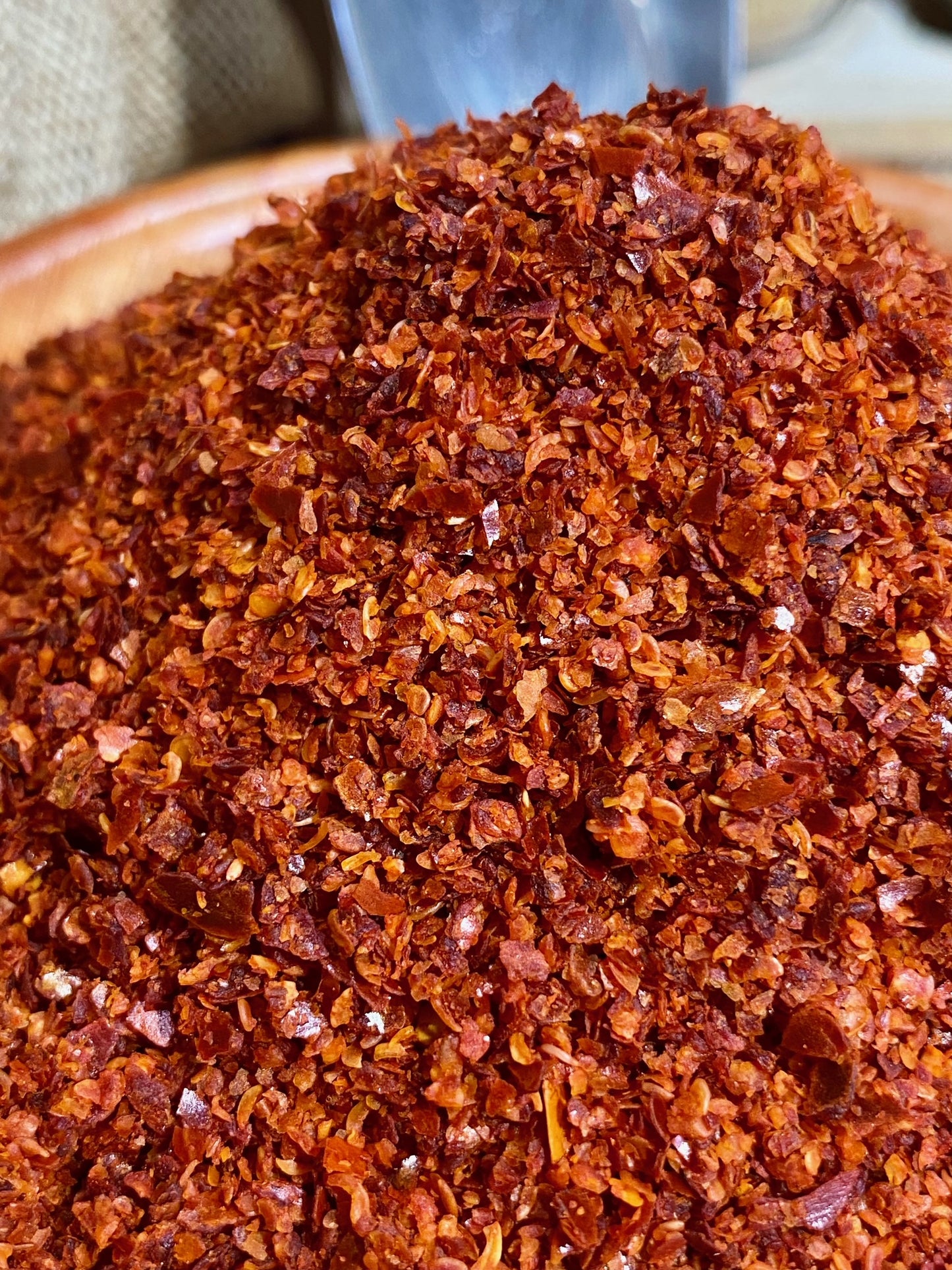 Gros plan sur la texture fine du piment d’Alep en poudre rouge