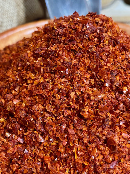 Gros plan sur la texture fine du piment d’Alep en poudre rouge