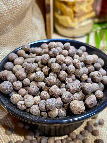 Détail des baies de piment de Jamaïque entières, épice aromatique utilisée en cuisine salée et sucrée