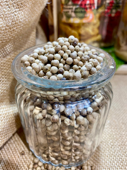 Gros plan sur grains blancs de poivre Malabar pour moudre et libérer arômes