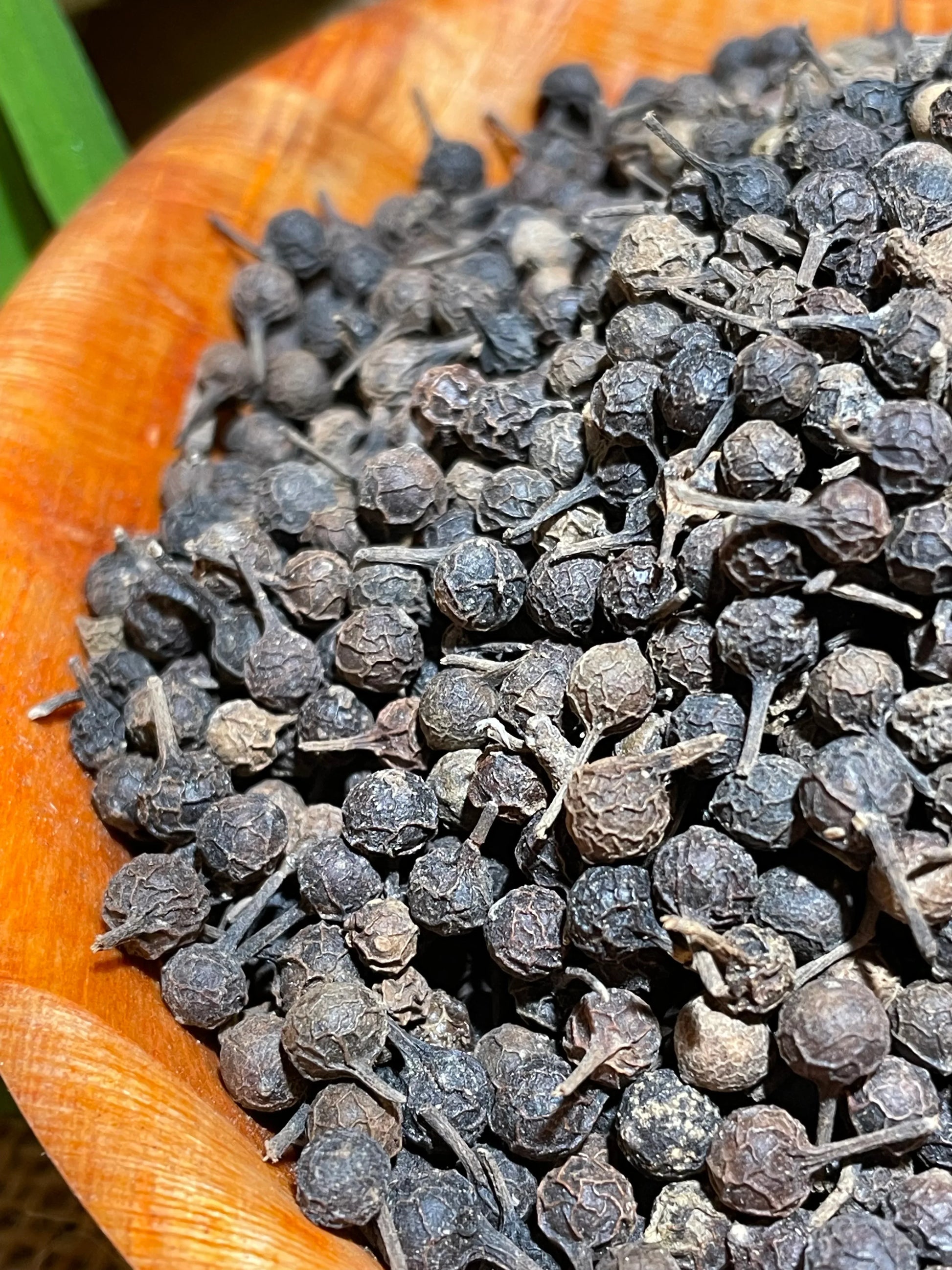 Gros plan sur les grains de poivre cubèbe avec leur queue caractéristique
