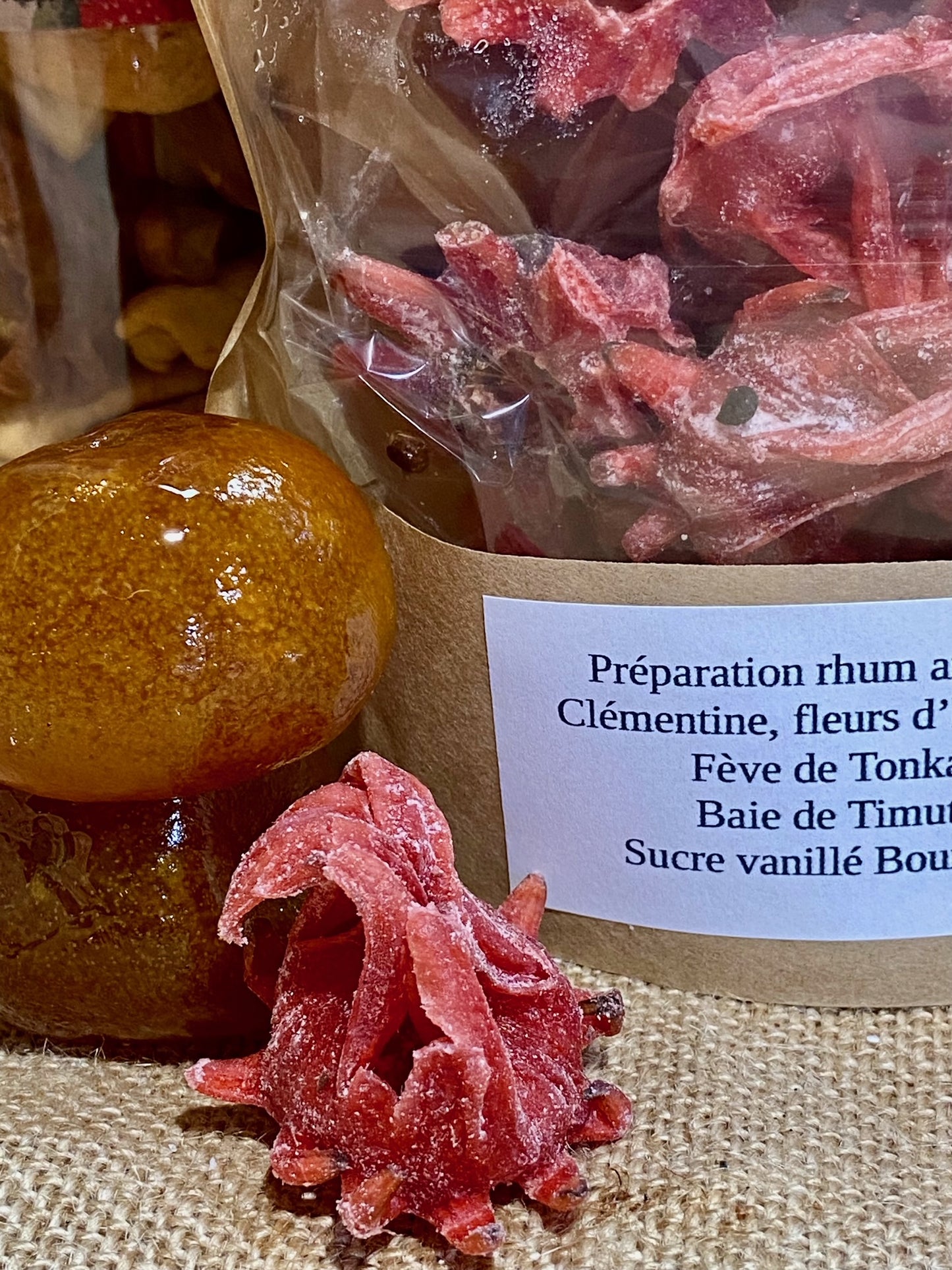 Sachet de préparation pour rhum arrangé Clémentine Hibiscus ouvert – ingrédients prêts à être versés dans une bouteille de rhum pour infusion maison fruitée
