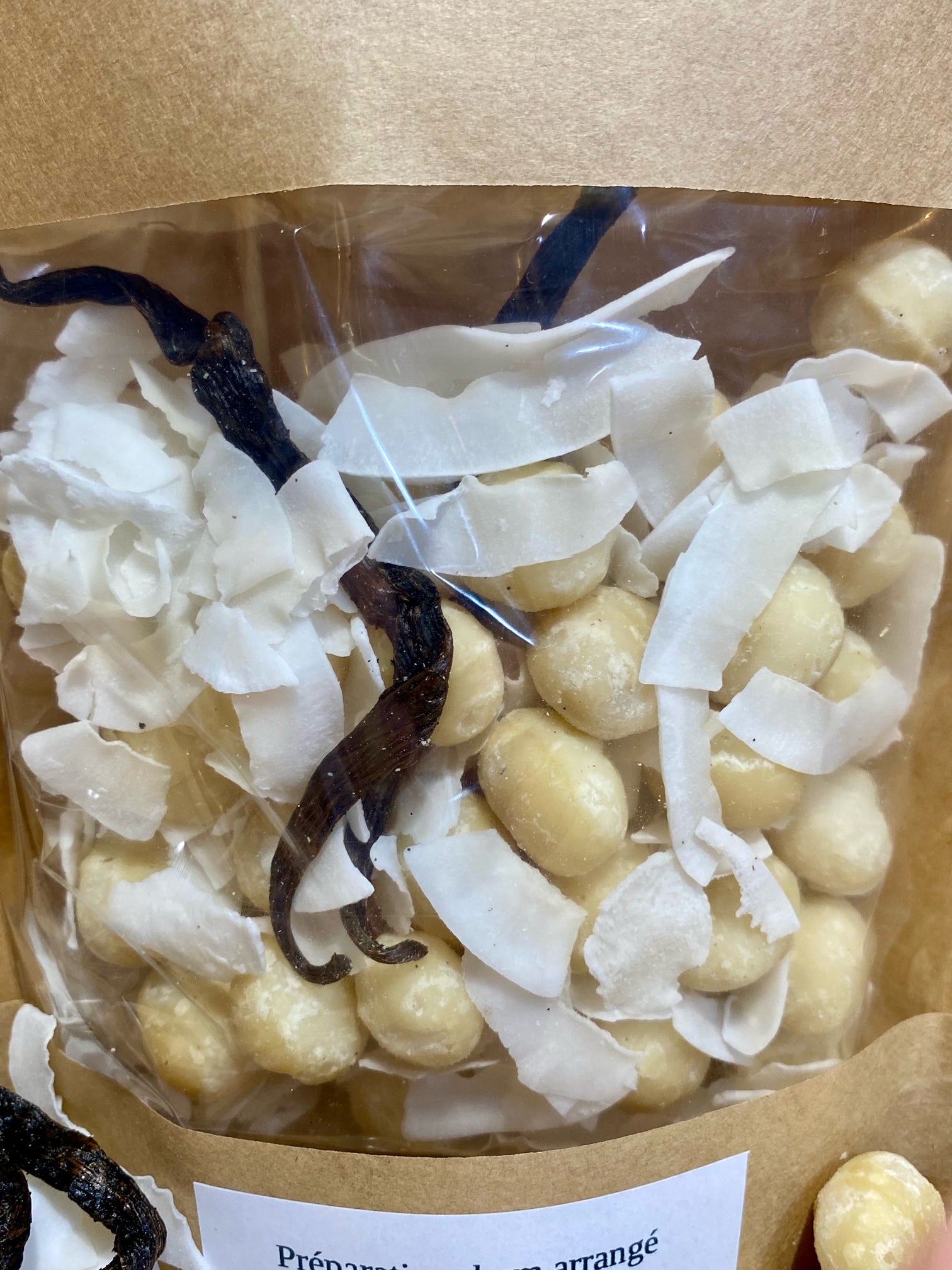 Gros plan sur ingrédients pour rhum arrangé noix de macadamia et coco – morceaux de noix de macadamia, noix de coco et vanille séchées prêts à infuser dans le rhum pour un arôme riche