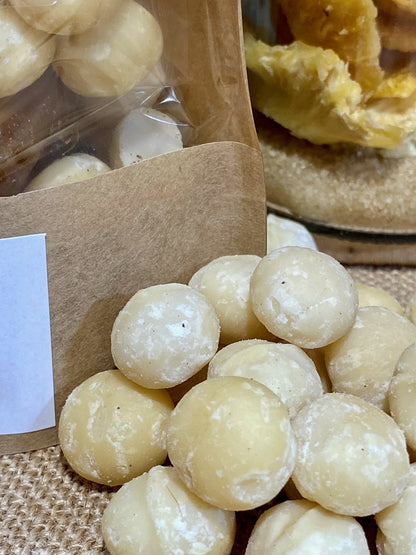 Sachet de préparation pour rhum arrangé Macadamia Timut ouvert montrant les fruits secs, clémentine et épices prêts à être versés dans une bouteille de rhum pour infusion