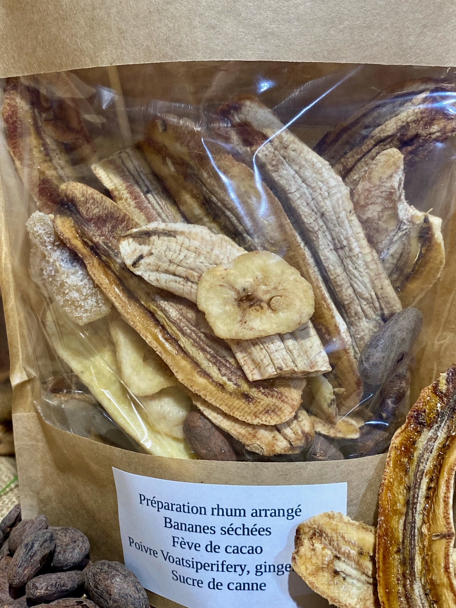 Gros plan sur préparation de rhum arrangé noix de pécan – morceaux de noix de pécan, bananes séchées, vanille de Madagascar et cannelle de Ceylan prêts à infuser dans du rhum blanc