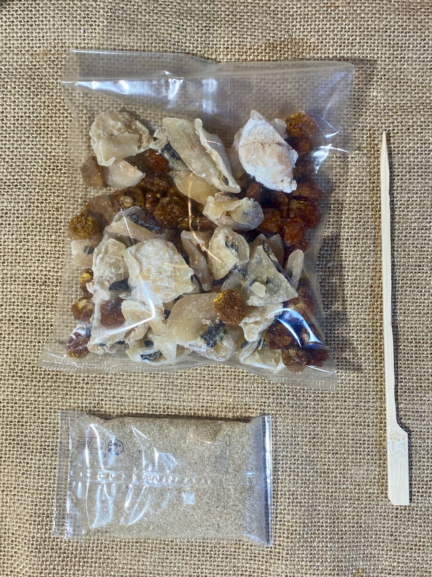 Sachet de préparation pour rhum arrangé Physalis Tonka ouvert – montre les physalis séchés, fève de Tonka et sucre vanillé prêts à être versés dans une bouteille pour macération